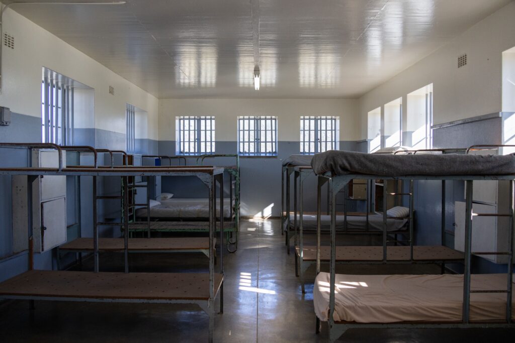 Juvenile detention center with two rows of bunk beds lining the walls